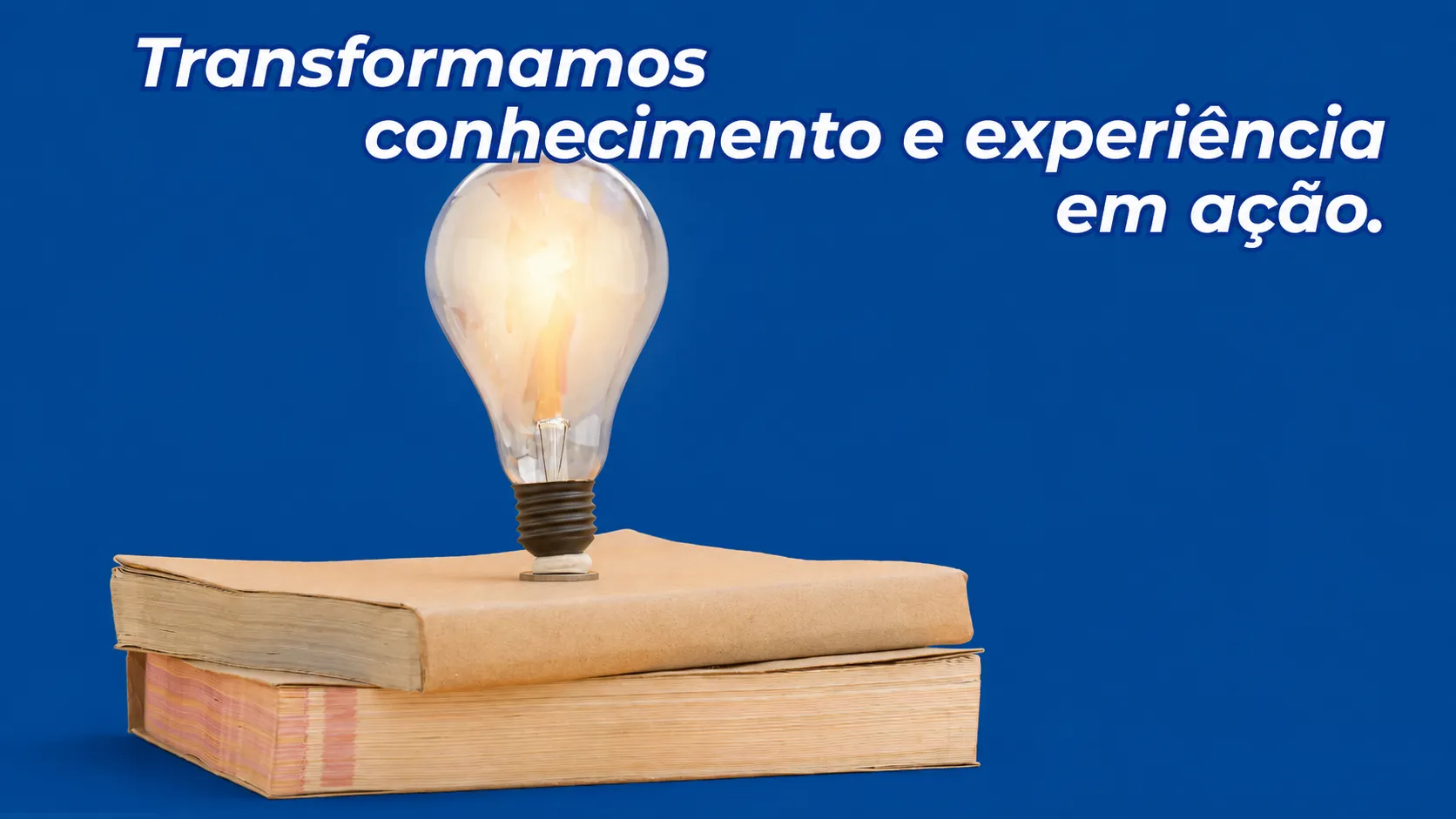 Lâmpada acesa sobre uma pilha de livros, simbolizando conhecimento e experiência